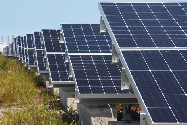Row of commercial solar panels on a solar farm